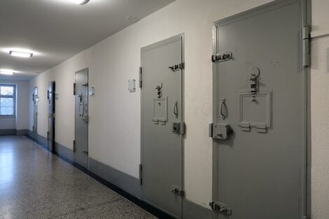 A prison corridor with locked steel doors.