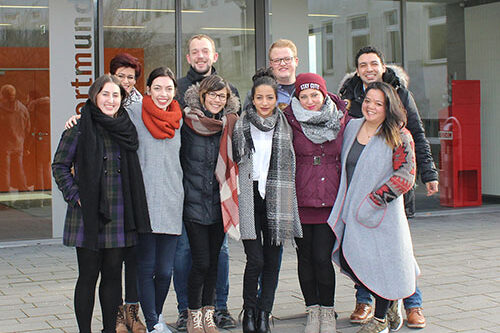 A group of young adults stand in front of a building at Fachhochschule Dortmund.