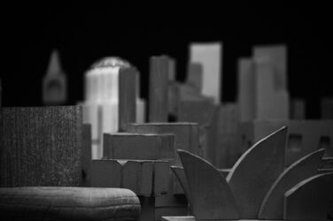 Schwarz-Weiße Nahaufnahme aus einer Froschperspektive von den aus Feinkornbeton gegossenen Gebäude-Skulpturen. Die Skulptur im Vordergrund erinnert an die berühmte Oper in Sydney.