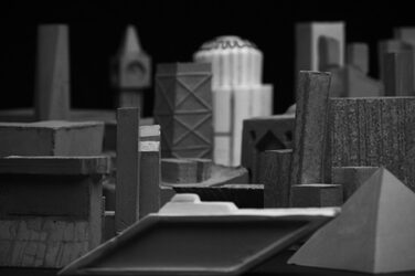 Black and white image of the building sculptures in landscape format. It looks as if you are looking over the roofs of a city made of fine-grained concrete.