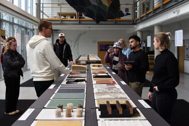 Staff member Daniel Horn explains the properties and applications of some of the materials to students as part of the exhibition tour