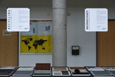 The foreground shows 12 material samples, while at the same time two posters with content on sustainability and recycling are displayed in the background