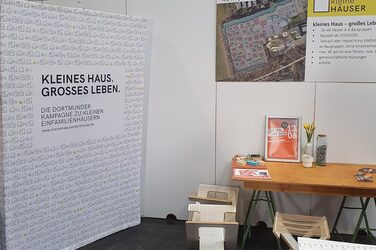 Der Messestand der Stadt Dortmund umfasst unter anderem Stellwand, Tisch und Sitzmöglichkeiten.