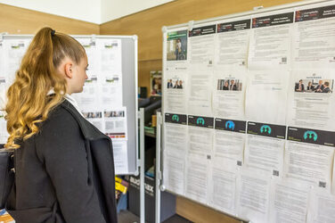 A student looks at job offers on a display wall.