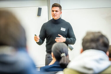 A company representative gives a presentation to students.