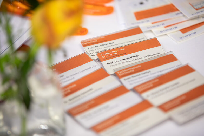 Name tags of participants, laid out on a table with flowers.