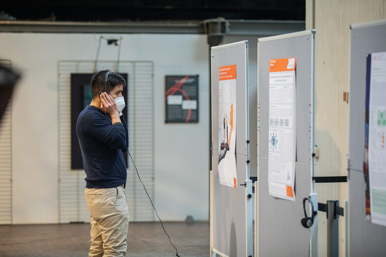 A participant looks at posters while listening to the corresponding soundtrack on headphones.