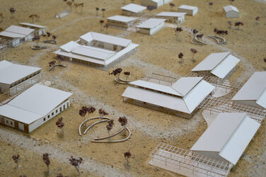 Model supervision with several single-storey building models made of white cardboard.