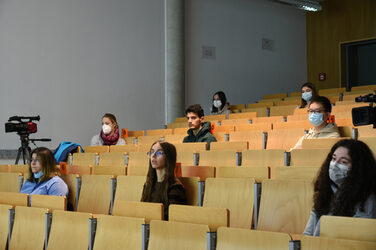 Schüler*innen sitzen mit Abstand zueinander im Hörsaal.