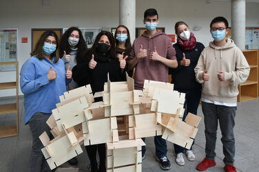 Gruppenbild der Schüler*innen des Steinbart-Gymnasiums Duisburg mit ihrer fertiggestellten Steckkartenskulptur, gemeinsam mit der Lehrenden Eva Paar.