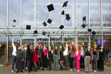 The graduates let their hats fly outside the Faculty of Architecture.