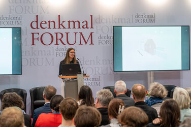Student Luisa Demmer presents her design in front of an audience on the Messeakademie stage.