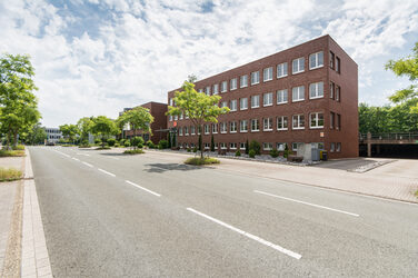 Foto der Otto-Hahn-Straße mit mehreren Gebäuden der Fachhochschule Dortmund sowie Bäume entlang der Straße.