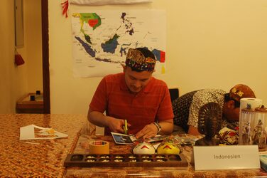 Kulturstand Indonesien: Ein Studierender an einem dekorierten Tisch