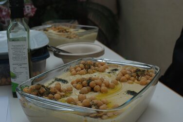 Kulturstand Syrien: Nahaufnahme einer großen Schale Hummus auf einem dekorierten Tisch
