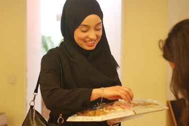 Eine Studentin, die eine Schale mit Essen in der Hand hält.