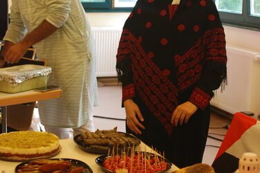 Students at a table with food at the Palestinian cultural stand.