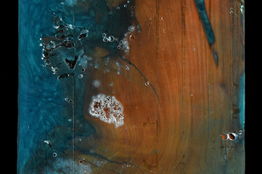 Quadratische Holzplatte bei der die Unebenheiten mit einem blau eigefärbtem Harz vergossen und anschließen geschliffen wurden