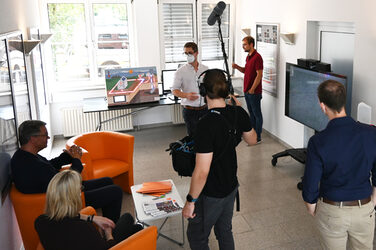 Philip Wizenty presents the PuLS project to the Lord Mayor on a large television in the IDiAL hallway