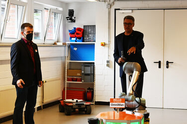 OB Thomas Westphal und Daniel Heß stehen um OmniMan im Roboterlabor des IDiALs.