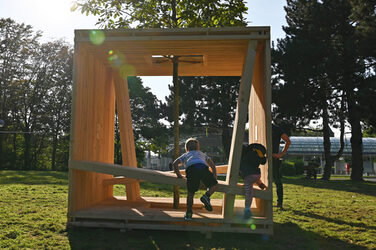 The Fachhochschule Dortmund's wooden seating cube is located in a green area near the Westfalenhallen subway station.