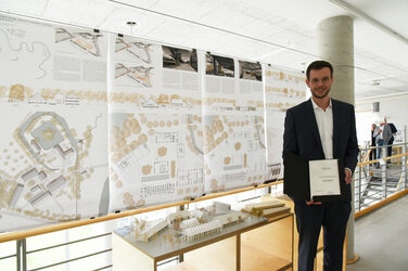 Graduate Jan Erik Nienhaus at the exhibition in front of the plans for his Master's thesis on the faculty's galleries.