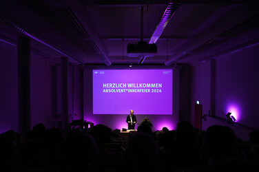 View of the colorful illuminated screen in the lecture hall with the inscription "Welcome - Graduation 2024".