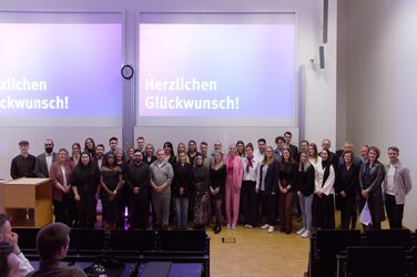 Group photo of the graduates on the stage of the lecture hall.