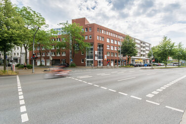 Foto eines Gebäudes an der Hohen Straße in Dortmund, davor die Hohe Straße und ein vorbeifahrendes Fahrzeug.