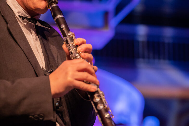 Photo of a male person playing a clarinet.