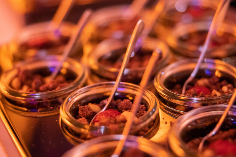 Photo of food in glasses. There is a spoon in every glass.