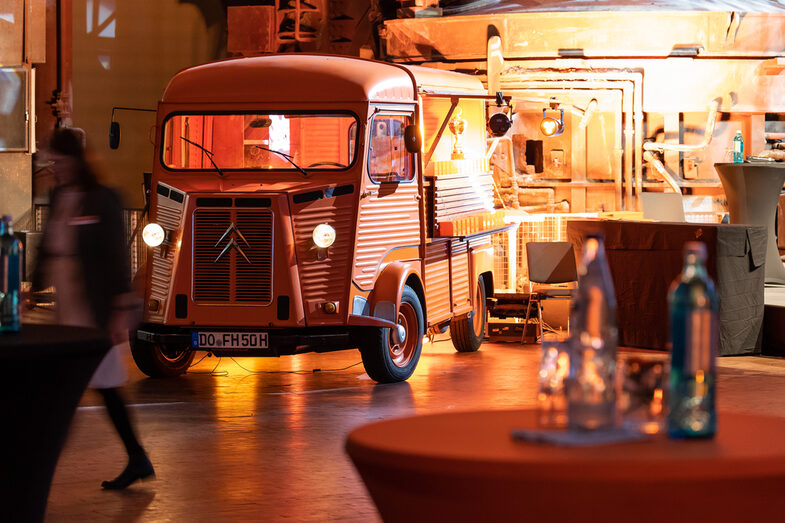 Photo of an illuminated hall. Inside is a Citroen HY with the side flap open.