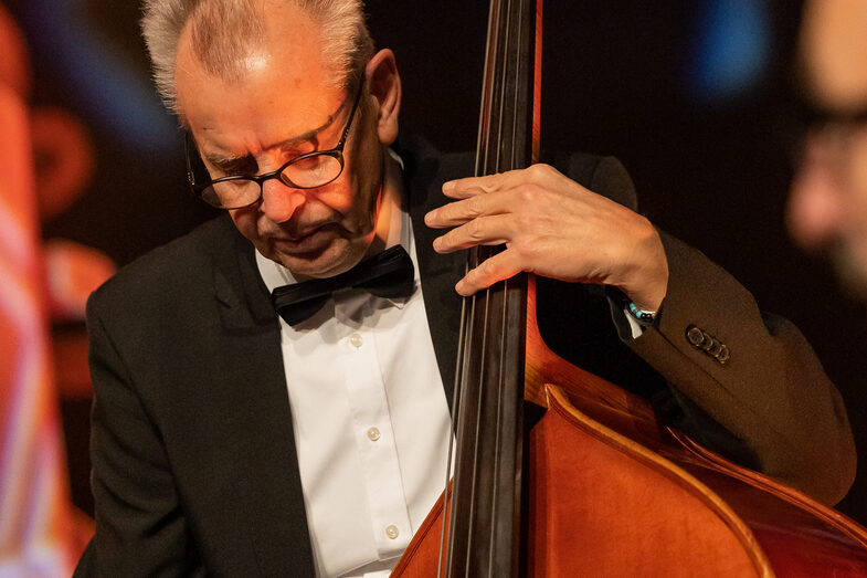 Photo of a male person playing a bass.