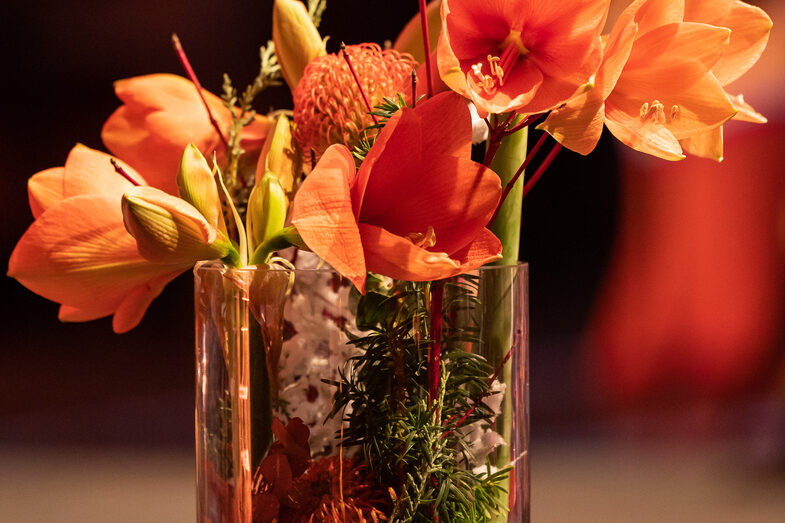 Photo of orange flowers in a glass vase.