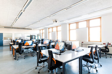 Room shot of the laboratory for networks and operating systems, with several rows or groups of tables equipped with computers.