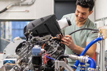 A picture showing a student working on a technical machine