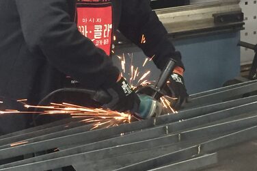 A student grinds the metal edges of a railing and sparks fly.