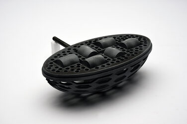 Entwurf 3: schwarzes, ovalförmiges Modell „Alltagshelfer“ aus generativ gefertigten Elementen vor weißem Hintergrund