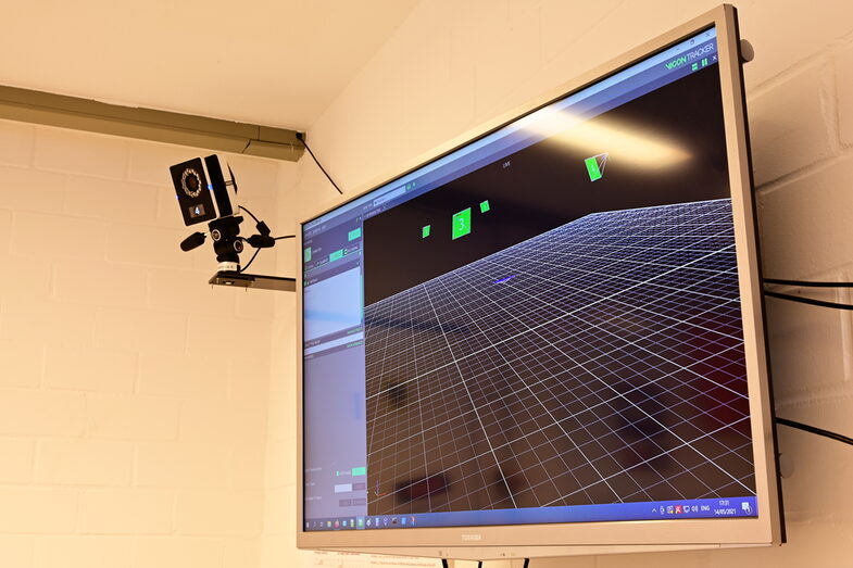 Eine Kamera an der Wand und ein Bildschirm der die Software des Kamerasystems zeigt__A camera on the wall and a screen showing the software of the camera system
