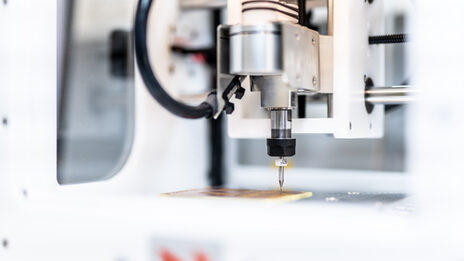 Close-up of a milling machine milling something onto a circuit board.