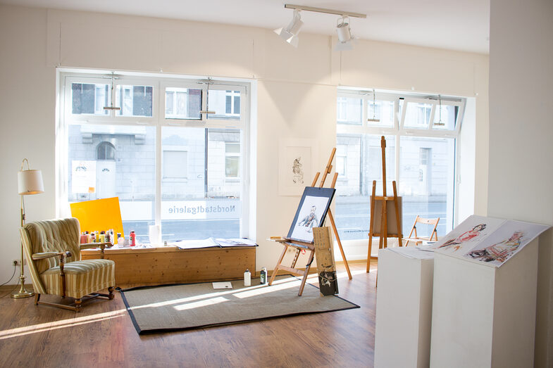 Interior view of the Nordstadtgalerie: a room with large windows containing antique furniture and various painting utensils