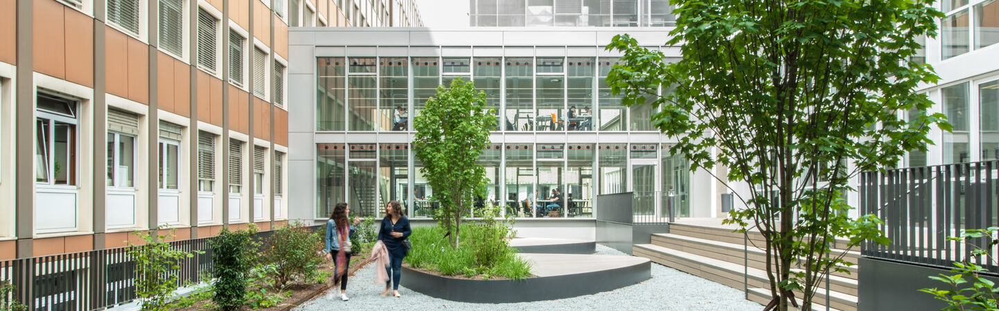 Foto vom Innenhof bei den studentischen Arbeitsplätzen an der Sonnenstraße. Im Innenhof laufen zwei Frauen.