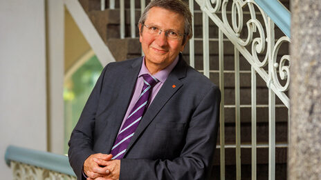 Portrait of former rector Prof. Dr. Wilhelm Schwick, leaning against the banister.