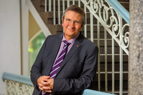 Portrait of Rector Prof. Dr. Wilhelm Schwick, leaning against the banister.