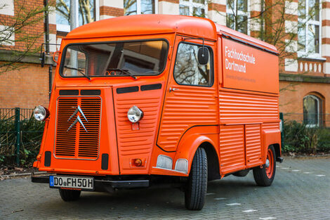 Der orangefarbene Citroen HY steht vor dem FH-Hauptgebäude an der Sonnenstraße.