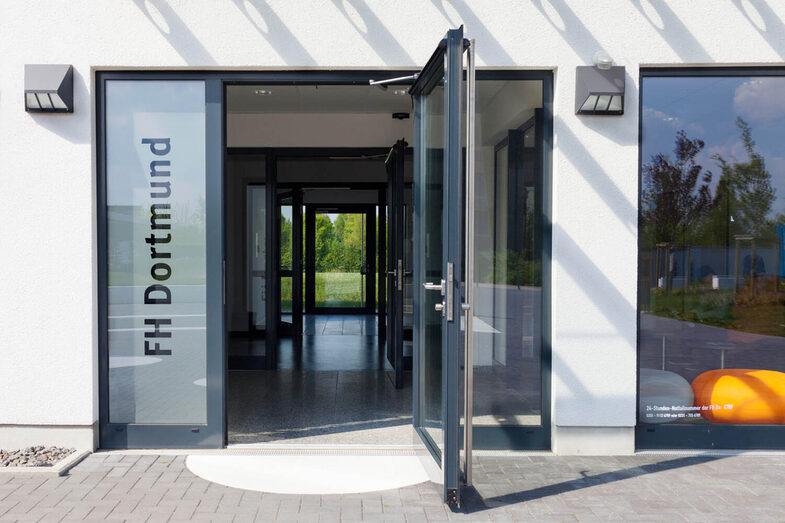 An open glass door with "Fachhochschule Dortmund" written on the pane