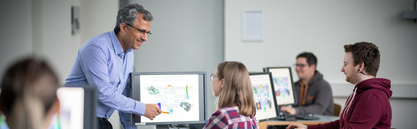 Photo of a lecture of the Department of Mechanical Engineering. A lecturer explains a technical drawing to students on a screen __Photo of a lecture of the Department of Mechanical Engineering. A lecturer explains a technical drawing to students on a screen.