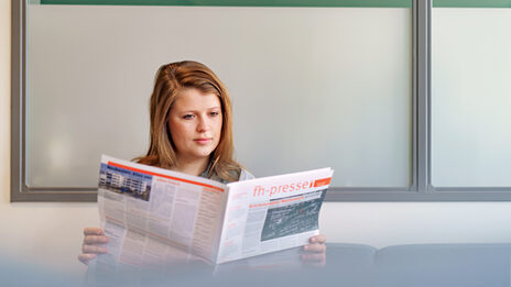 Foto einer Studentin, die in der FH-Presse liest.__A young woman reads the FH-Presse.
