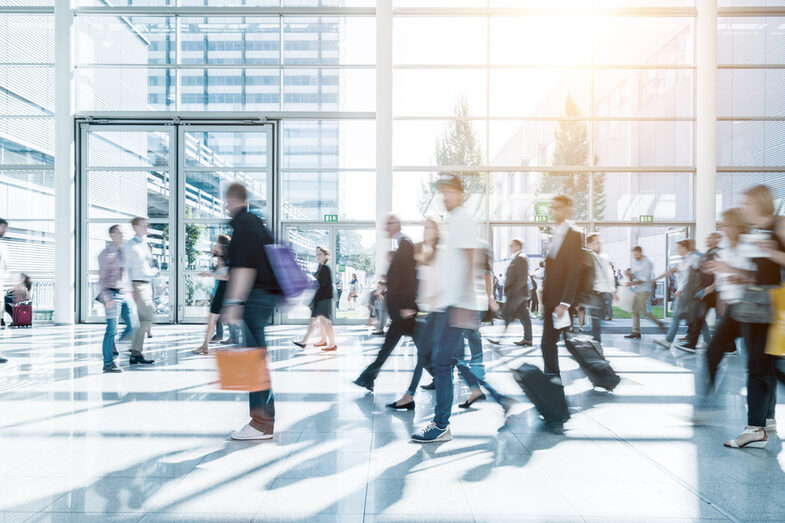 Photo of a bright foyer with people walking around who are only blurred by the movements.