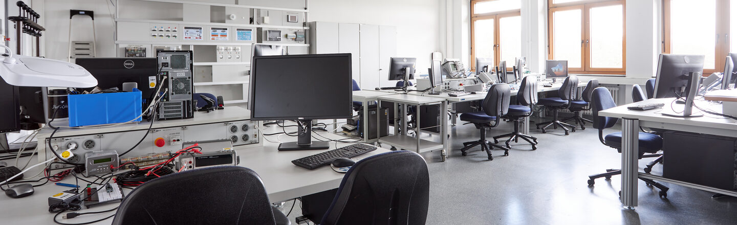 Here you can see other workstations and the previously described workstation with the experiment set up at the back right. At the foremost workstation in the picture you can see another experimental setup.